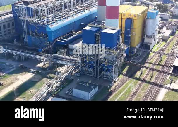 Industrial power plant with blue and yellow structures, featuring smoke ...