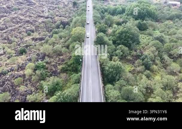 Volcantic Rocks Aerial view of cars riding along a winding mountain road surrounded by ...
