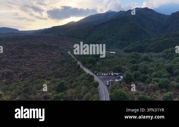 Scenic aerial view of winding road through lush green hills and ...