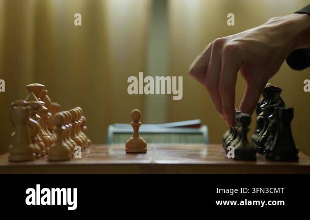 Side view of a wooden chessboard as two players make opening moves ...