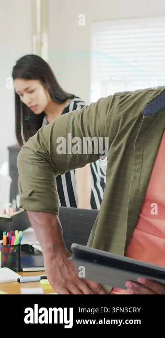 Vertical video: Man leaning on desk shifting pad, woman writing notes ...