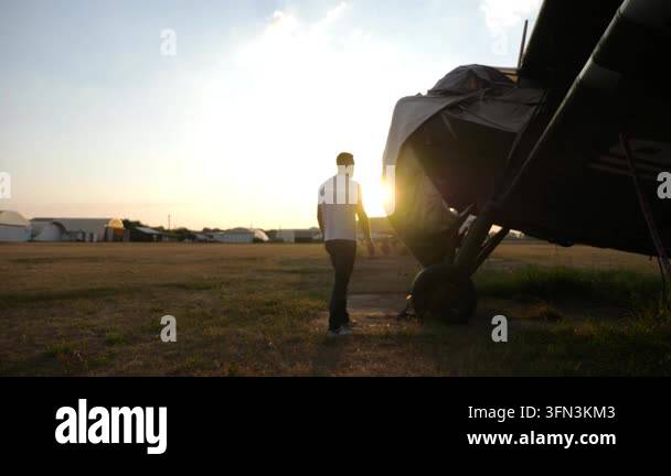 Individual inspects vintage aircraft, revealing covered sections while ...