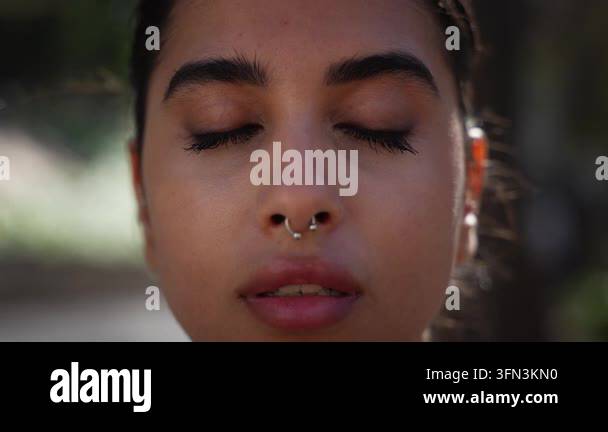 Close-up portrait of a young Iranian woman outdoors with eyes closed in ...