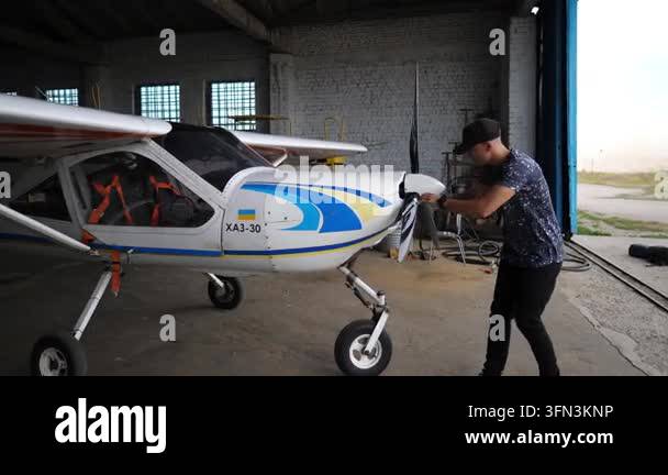 Pilot conducts thorough inspection of aircraft engine in hangar ...