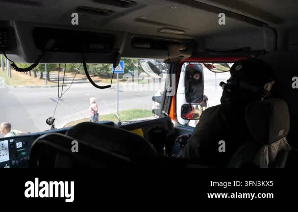 Professional fireman in uniform riding on a big truck to place of a ...