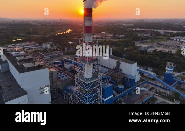 Aerial view of thermal power plant at sunset, showcasing smokestack ...