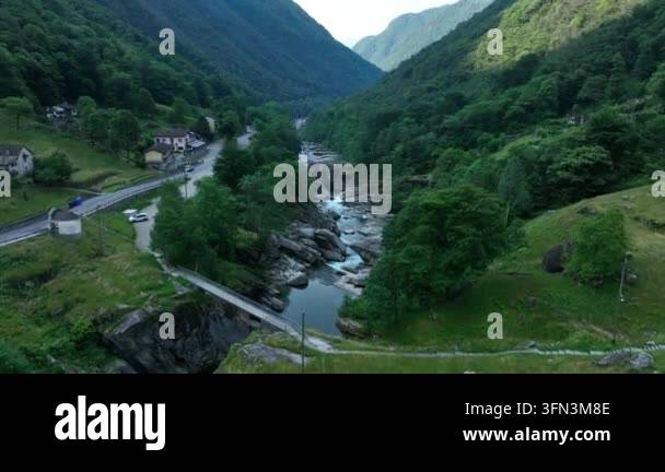 Aerial drone footage flying over a winding river flowing through a lush ...