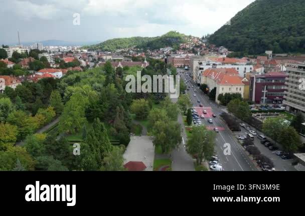Aerial view of a city street with cars driving and trees lining the ...