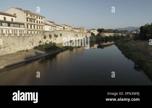 Aerial view of a river flowing past an ancient stone wall and buildings ...