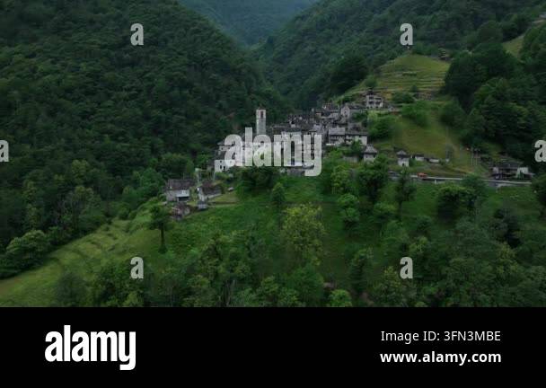 Aerial drone view of a historic village nestled in a lush green ...