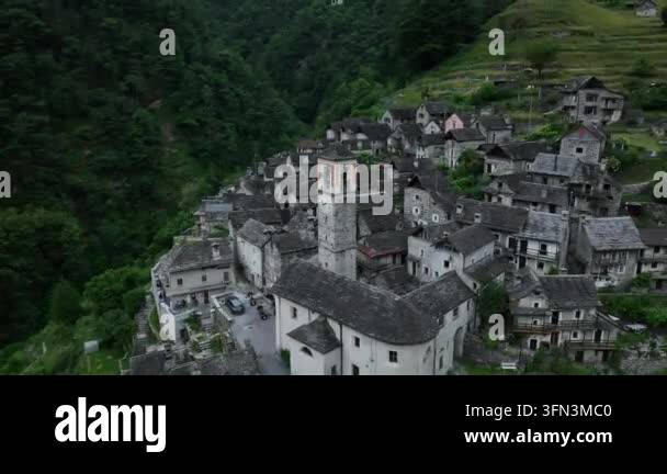 Aerial view of a historic village nestled in a lush green valley with ...