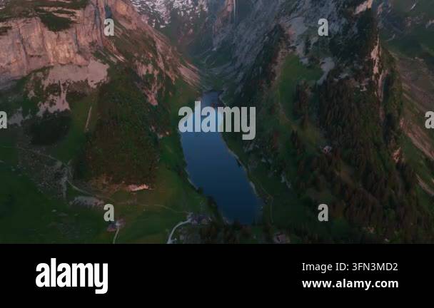 Aerial drone view of a serene mountain lake surrounded by lush green ...