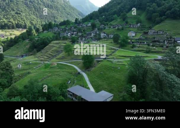 Aerial drone view of a small village nestled in a lush green mountain ...