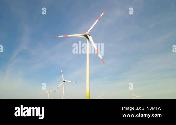 Wind turbines spinning tall against blue sky Stock Video Footage - Alamy