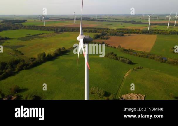 aerial view of wind turbines spinning in green fields on a sunny day ...