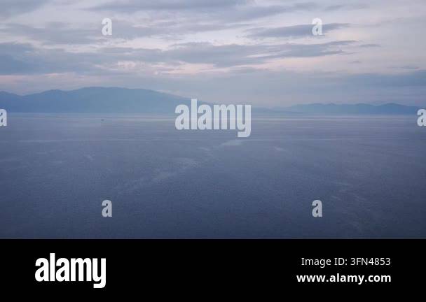Calm blue ocean water under a cloudy twilight sky Stock Video Footage ...
