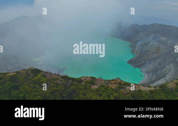 Volcantic Rocks Turquoise volcanic crater lake surrounded by thick white mist Stock ...