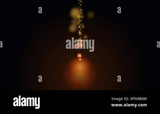 Abstract background of glowing golden particles rising from a warm ...
