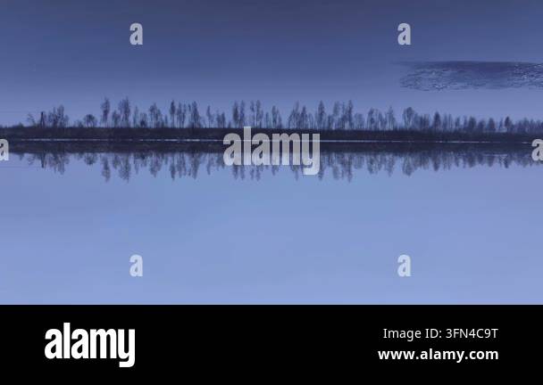 Calm water reflecting trees under blue sky Stock Video Footage - Alamy