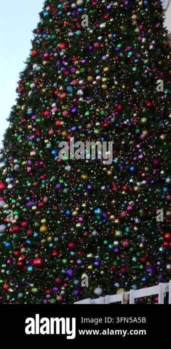 Vertical close up of a Christmas tree covered with colorful ornaments ...