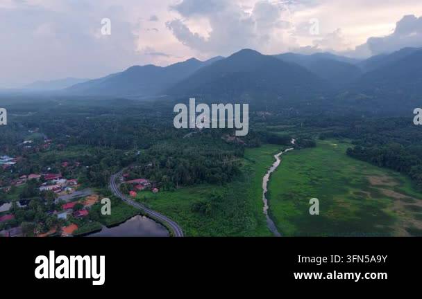 Aerial view of a winding road passing through a lush green valley ...
