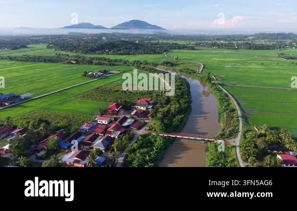 Aerial view of river meandering through lush green fields at Perai ...