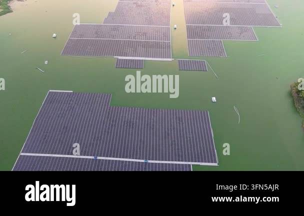 Aerial view showcasing solar panels floating on a vibrant green water ...