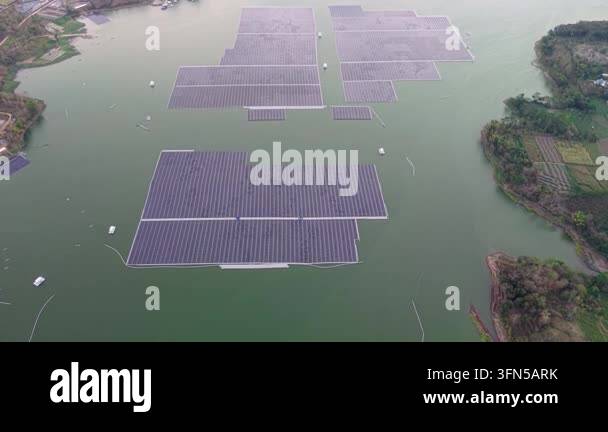 Floating solar panels gleam on calm, green waters. Arrays spread across ...