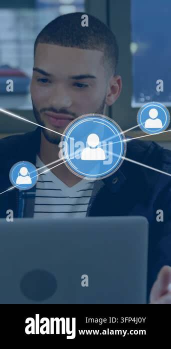 Vertical video: Seated man using laptop showing blue nodes spreading as ...