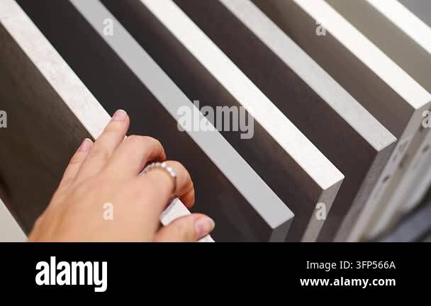 Woman touches countertop samples while choosing material in furniture ...