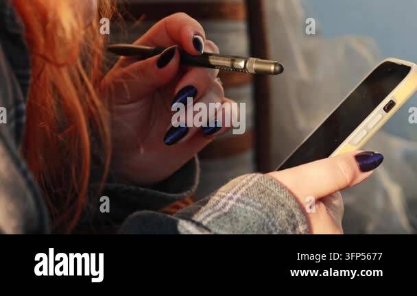 Horizontal close-up shot of a woman holding a smartphone and a multi ...