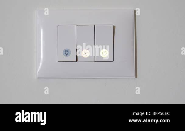 Woman pressing touch button to turn on indoor light on modern wall ...