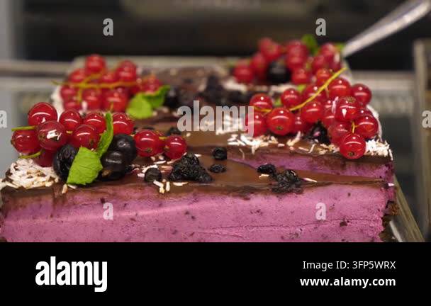 Berry Box Display Decorated berry cake rests in bakery case, with glossy chocolate ...