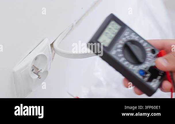 Socket Multimeter Hands use a digital multimeter and test probes to measure voltage in an ...