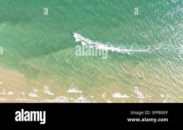 Drone footage aerial view of a small speed boat moving across clear ...