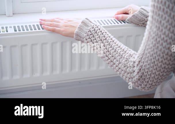 Body part of frozen woman hands checking warm radiator. person hand ...