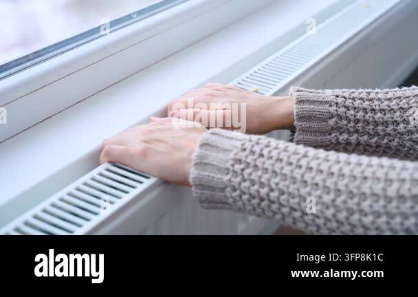 Body part of frozen woman hands checking warm radiator. person hand ...