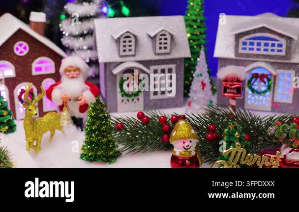 A funny little Santa Claus is jumping in front of a beautiful Christmas ...