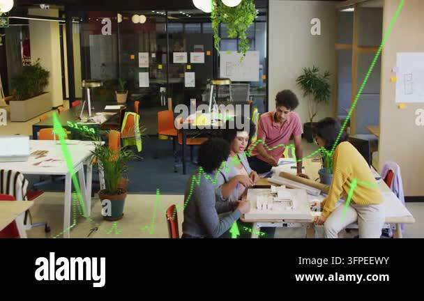 Design team unrolling plans pointing at model refining plan while green ...