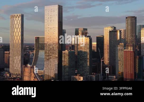 Folder Rack Tall Skyscrapers of Canary Wharf in London reflect warm golden light at ...