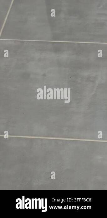 Gray Pattern Matte A handheld view moves across smooth gray floor tiles with pale grout ...