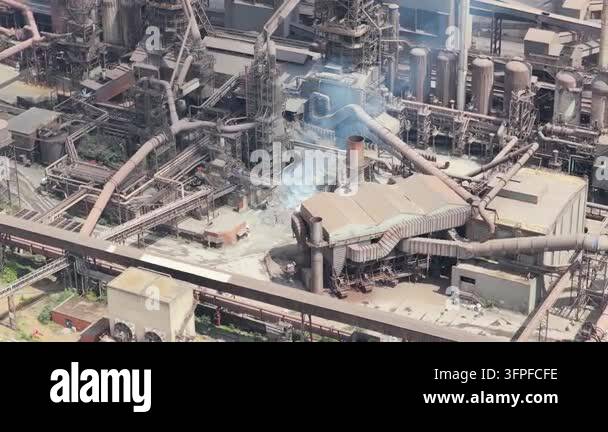 Expansive industrial steel mill operates with active production. White ...