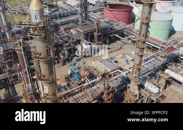 Aerial view reveals a vast industrial chemical plant. Numerous tall ...