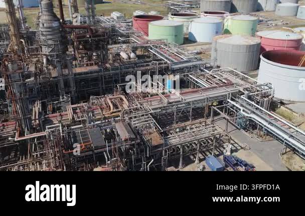 Broad view of a vast oil refinery facility during the day. It ...