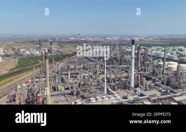 An aerial perspective shows a vast industrial oil refinery with ...