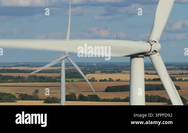Folder Rack Tall White wind turbines stand tall, their blades rotating against a bright ...