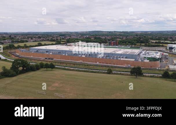Daytime aerial shot showcases a large Data Center building amidst green ...