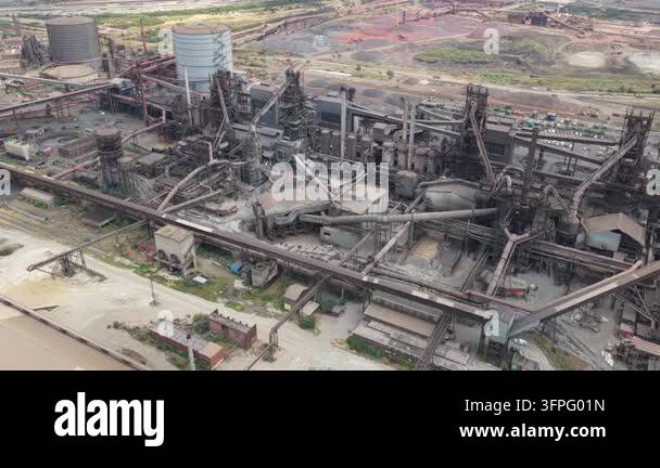 An aerial view reveals a sprawling steel mill complex under daylight ...