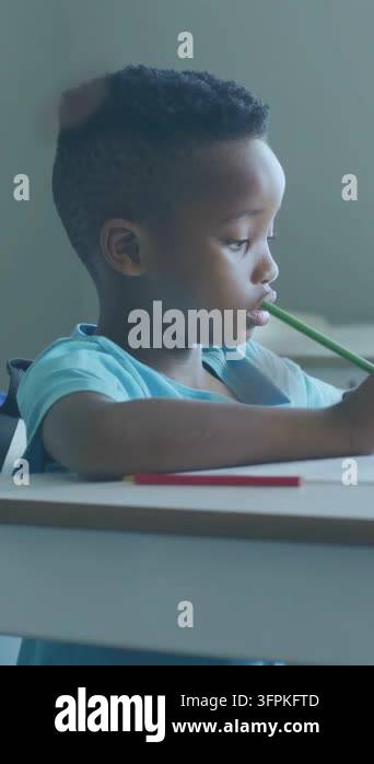 Vertical video: Boy finishing worksheet writing with green pencil ...