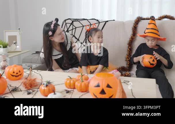 Corn Rows Stock Image Asian family enjoys Halloween party at home, mother braids hair for ...